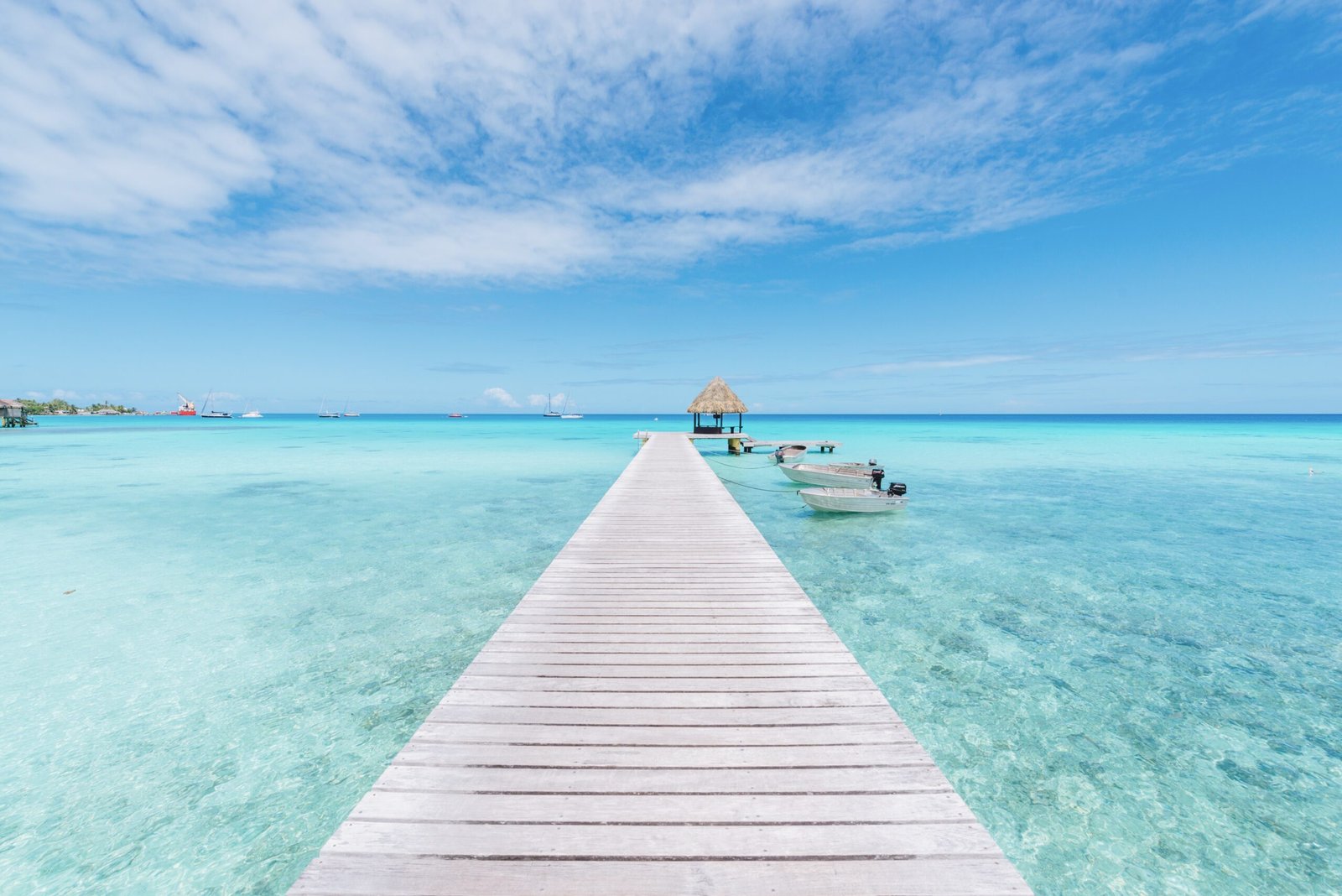 Wooden dock over crystal-clear blue water in Bacalar Lagoon