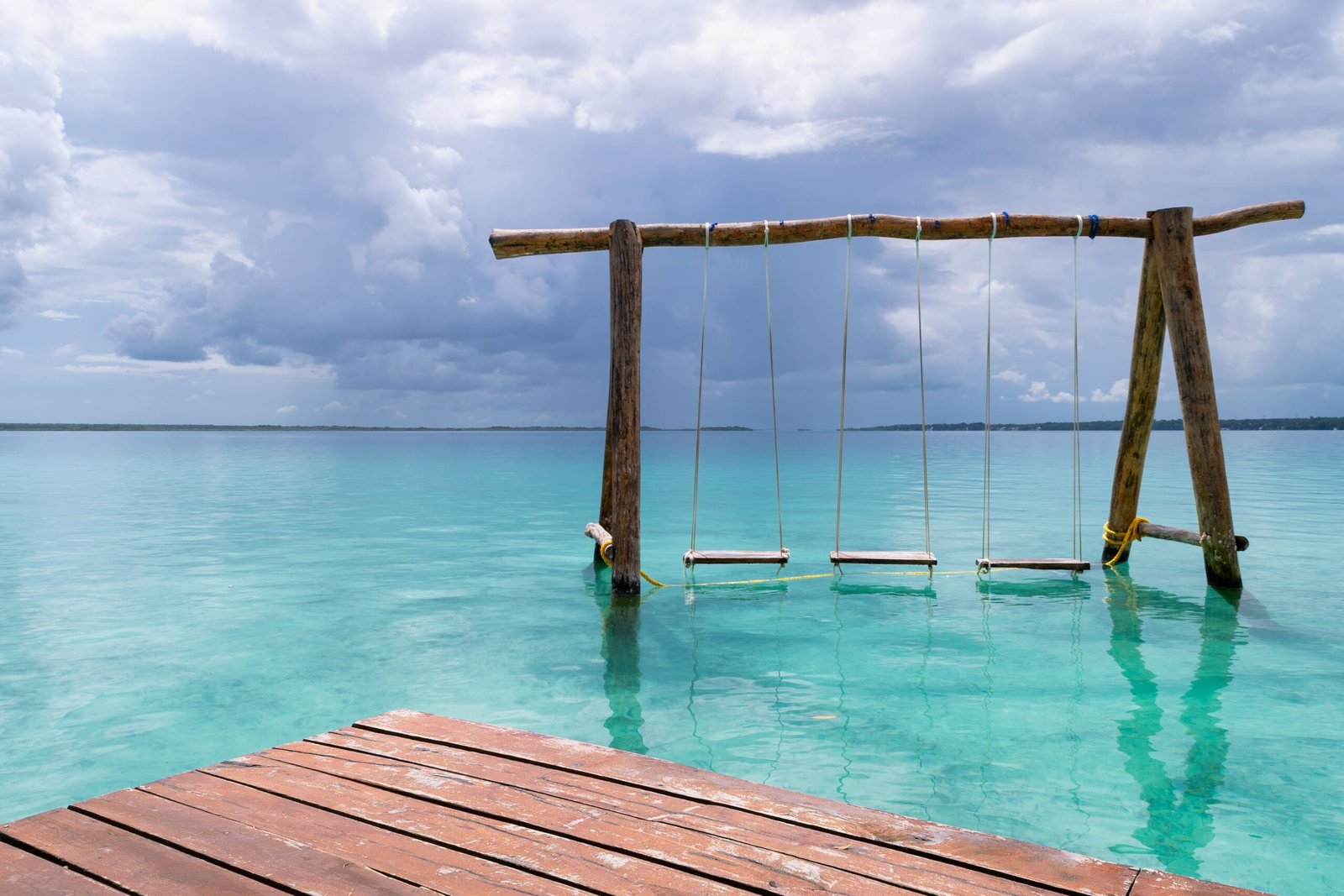 Wooden swings overlooking the turquoise Bacalar Lagoon in Quintana Roo