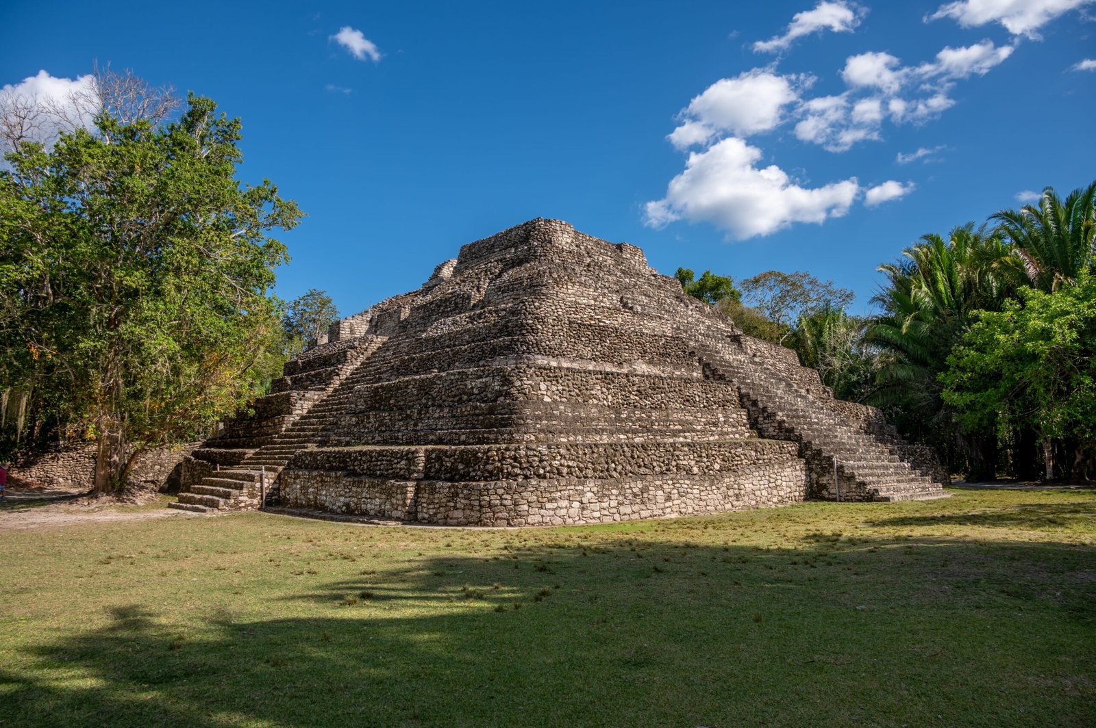 Maya pyramid surrounded by green vegetation at Chacchoben in Costa Maya
